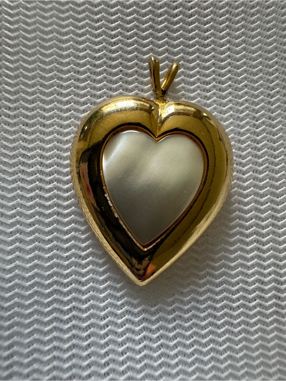 Gold pendant in heart shaped design with white shell opal center